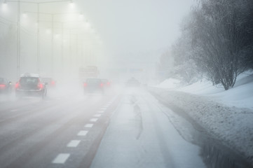 Road with traffic and heavy fog