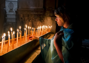 The pilgrims lit candles at the Church of the Holy Sepulchre in - obrazy, fototapety, plakaty