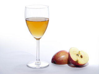 apple juice in a glass and sliced ??red apple, bright background