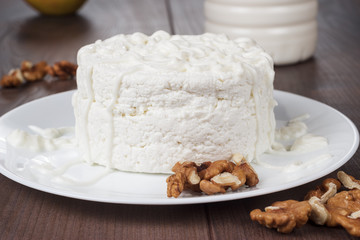 Cottage cheese in white plate on wooden table