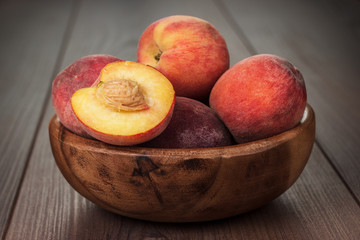 Fototapeta na wymiar wooden bowl with some peaches on the table