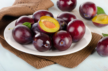 fresh plums on a white plate