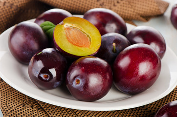 fresh plums on white plate