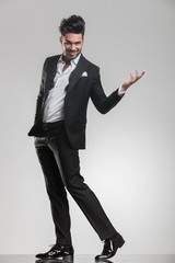 elegant man walking while holding one hand in the air