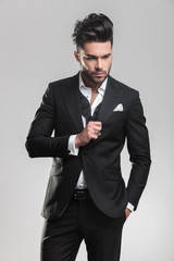 young man in tuxedo looking down while ajusting his tuxedo