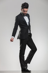 Young man in tuxedo looking down