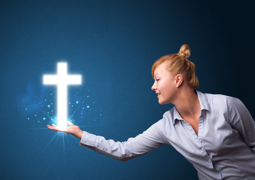 Glowing cross in the hand of a businesswoman