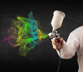 Painter working with airbrush and paints colorful paint