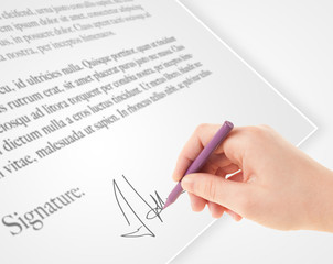 Hand writing personal signature on a paper form