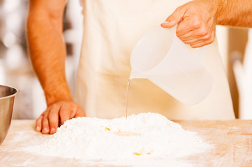 Obraz na płótnie Canvas Adding some water to flour.