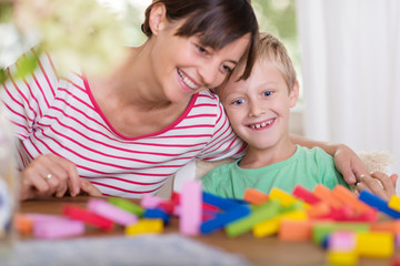 mutter und sohn spielen domino und lachen