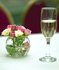 Bouquet of roses and glass of champagne