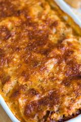 meat lasagna with mushrooms in a white bowl on a blackboard