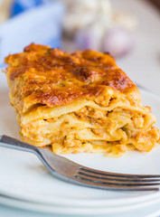 piece of meat lasagna with mushrooms on a round plate