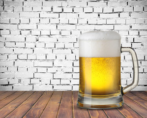 Mug of beer on white brick wall