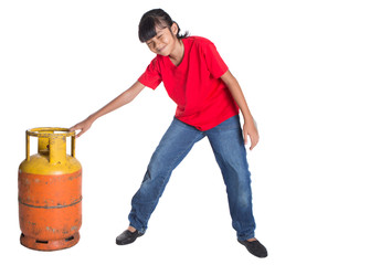 Young Asian girl moving an old cooking gas propane cylinder 