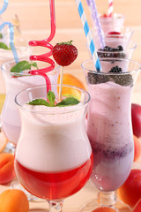 Delicious milkshakes on wooden table, close-up