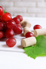 Wine bottle corks with grapes on table close-up