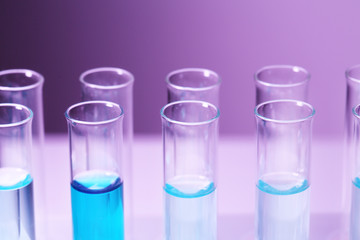 Test-tubes with blue liquid on purple background