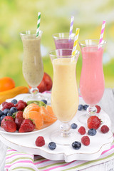 Delicious berry cocktails on table on bright background