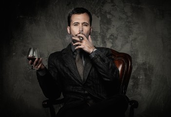 Handsome well-dressed with glass of beverage and cigar