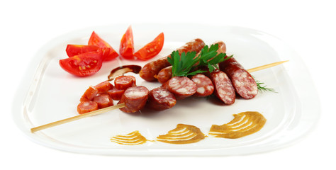 Assortment of tasty thin sausages on plate isolated on white