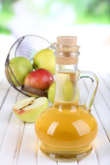 Apple cider vinegar in glass bottle and ripe fresh apples,