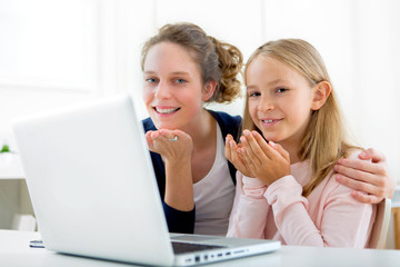 Attractive woman and little sister videocalling
