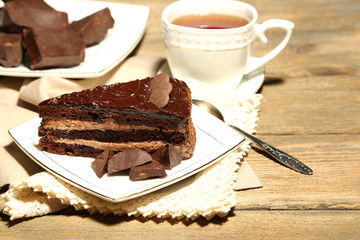 Chocolate cake on plate, on wooden background