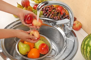Foto auf Acrylglas Woman's hands washing peaches and other fruits in colander in © Africa Studio