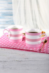 Two mugs of coffee with biscuits