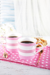 Two mugs of coffee with biscuits