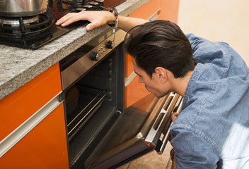 Man watching something cook in the oven