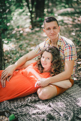 Pregnant woman with her husband having picnic in a forest