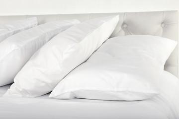 Fototapeta na wymiar White pillows on bed in room