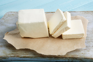 Fresh butter on cutting board, on color wooden background