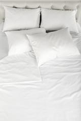 Fototapeta na wymiar White pillows on bed close up