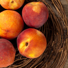 Fresh peaches on wood background. Selective focus.