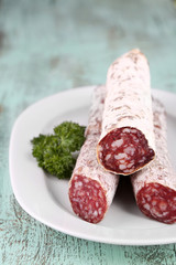 Italian salami on plate,  on wooden background