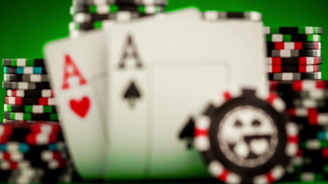 Stack of chips and two aces on the table on the green baize - po