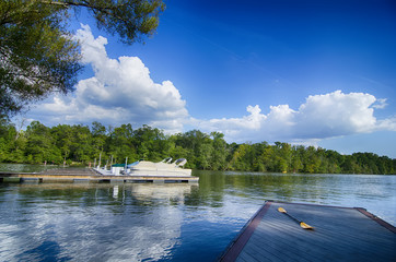 Fototapeta na wymiar boats at dock on a lake with blue sky