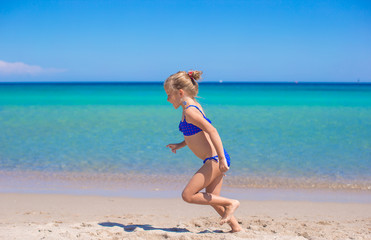Adorable little girl making wheel on tropical white sandy beach