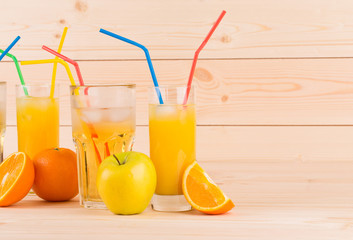 Orange juice and slices on wooden background.