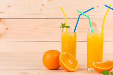 Orange juice and slices on wooden background.