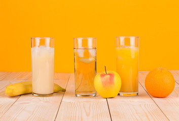 Three juices on orange background.