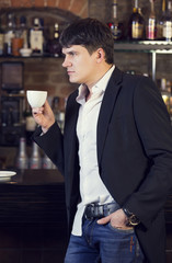 man drinking coffee near the bar