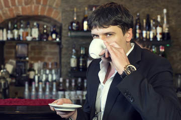 man drinking coffee near the bar