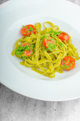 Pasta with basil pesto and pine nuts, cherry tomatoes