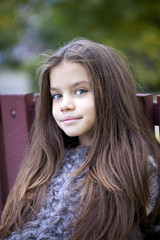 Naklejka premium Beautifal little girl in the autumn park