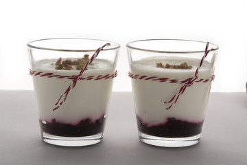 Layered dessert with fruits yogurt and cream cheese in glass jar